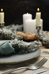 Plate, cutlery and Christmas decor on table, closeup