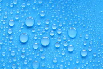 Water drops on blue background, top view