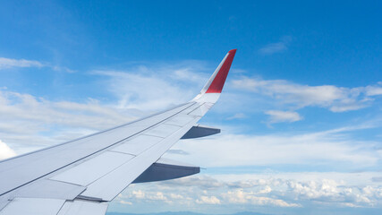 Obraz premium Airplane wing flying above the sky with white clouds. View from aircraft window. flying and traveling concept.