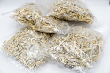 This close-up image showcases a textured mound of dried anchovies, their silvery bodies intertwined...