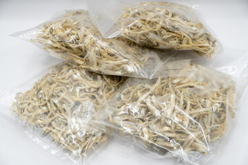 This close-up image showcases a textured mound of dried anchovies, their silvery bodies intertwined...