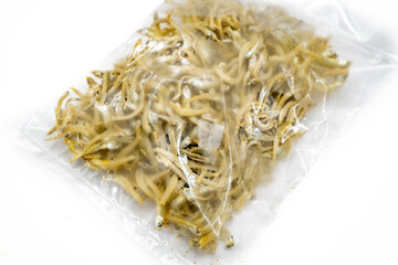 This close-up image showcases a textured mound of dried anchovies, their silvery bodies intertwined...