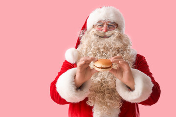 Santa Claus with tasty burger on pink background