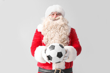 Santa Claus with soccer ball on white background