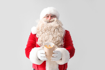 Santa Claus with tasty french fries on white background