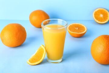 Glass of fresh orange juice on blue background