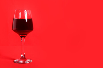Glass of wine on red background
