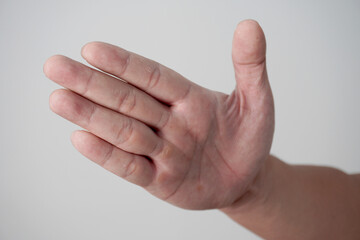 Hand of a person slapping gesture, over grey