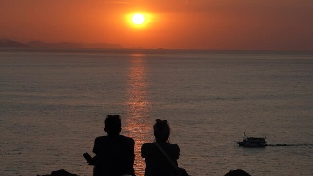A couple watching the sunset in the north of Labuan Bajo, A couple enjoying the sunset from a hill in the north of Labuan Bajo