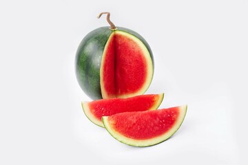 Whole watermelon and seeded slices seen front and top on a white background. Watermelon slices are red, seedy and juicy.