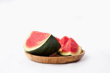 Whole watermelon and seeded slices seen front and top on a white background. Watermelon slices are...