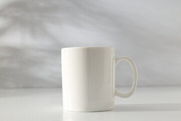 Obraz premium White classic cup on a light background