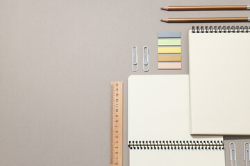 Open notebooks with stationery on a gray background