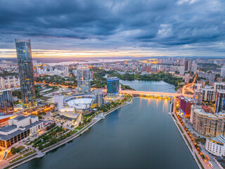 Obraz premium Yekaterinburg city and pond aerial panoramic view at summer or early autumn sunset. Night city in the early autumn or summer.