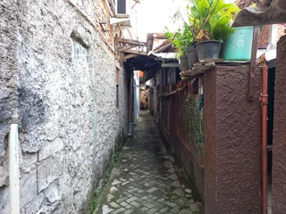 A densely populated residential area characterized by narrow alleys which is usually inhabited by people with a lower economic class