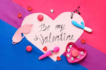 Sex toys with festive card, sweets and candles on bisexual pride flag. Valentine's Day celebration