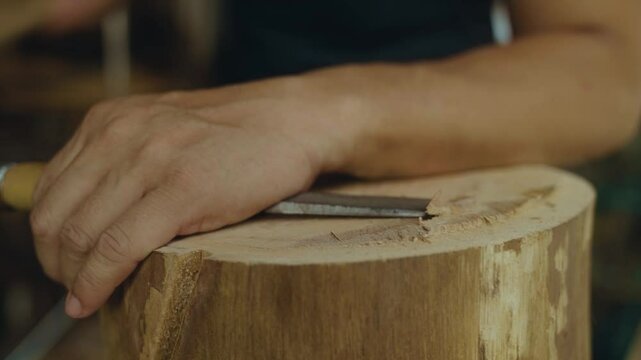 Detailed work of engraving a wood log with a chisel. Filmed in 4k 23.976 FPS