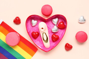 Heart shaped gift box with vibrator, rainbow LGBT flag and sweets on beige background. Valentine's...