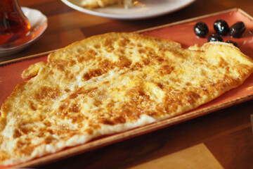 Plain Egg Omelette with olive on a long plate on table 