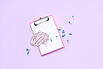 Clipboard, pills and paper human brain on lilac background