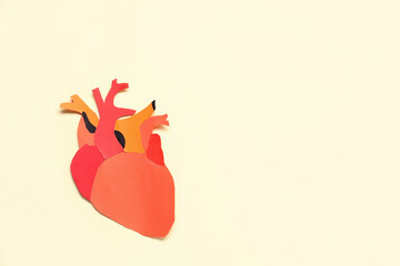 Paper human heart on beige background