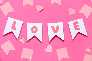 Paper flags with word LOVE and hearts on pink background. Valentine's Day celebration