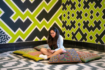 Young Latina woman capturing a photo of art at Museo de Arte de Lima (MALI) in Peru, focused and...