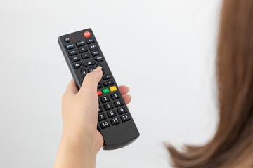 テレビのリモコンを操作する女性01 © yukinoshirokuma
