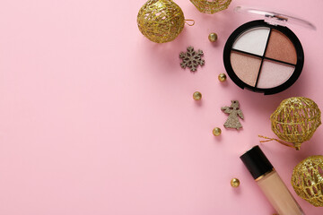 Beautiful composition with Christmas balls, makeup foundation and eyeshadow palette on pink background