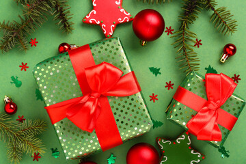 Beautiful composition with Christmas gifts, balls and gingerbread on green background