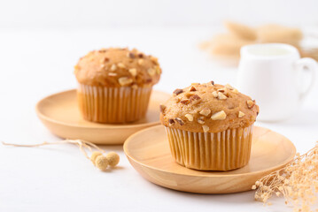 Vanilla almond muffin on wooden plate with white background
