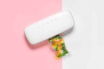 Vacuum sealer machine for food with chopped vegetables in pack on color background