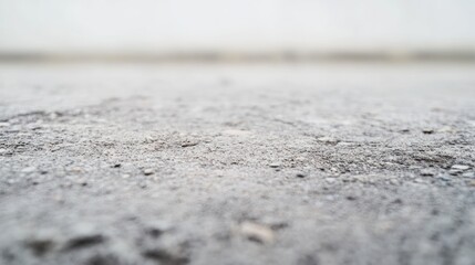 A close-up view of a textured gray surface, resembling concrete or asphalt.