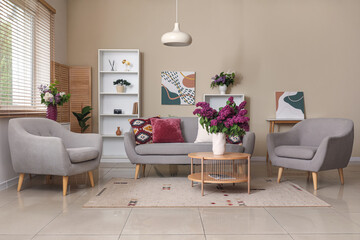 Modern interior of living room with lilac flowers in vase