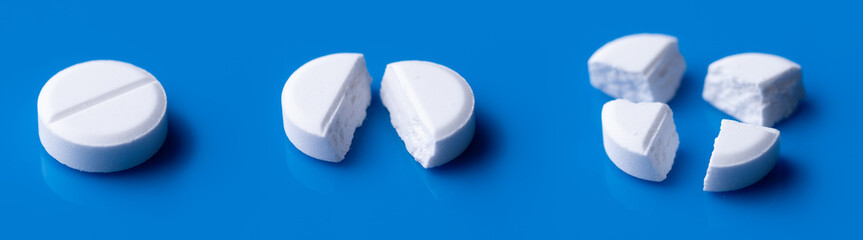 White broken pills lie on a blue background.Pharmacy medicament concept.