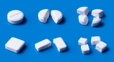 White broken pills lie on a blue background.Pharmacy medicament concept.