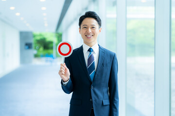 丸印のプレートを持つビジネスマン