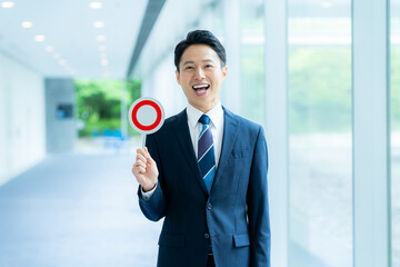 丸印のプレートを持つビジネスマン