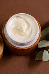 Face or body cream in bamboo jar with natural eucalyptus extracts and oils. Skin care cosmetics. Herbal treatment.