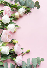 A beautiful arrangement of pastel flowers and eucalyptus leaves on a soft pink background showcasing their vibrant colors and textures