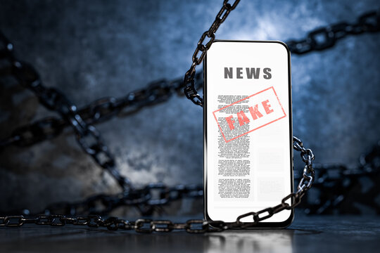 Fake news concept on a phone screen. Spreading disinformation in the state. Smartphone surrounded by a metal chain. Internet censorship. Social media scams. Conspiracy theories. 3D rendering.