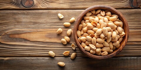 Peeled peanuts in a black bowl on wooden background fisheye