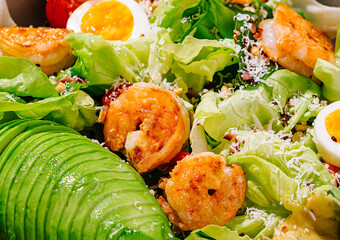 Delicious salad with shrimps, avocado and eggs being sprinkled with parmesan cheese