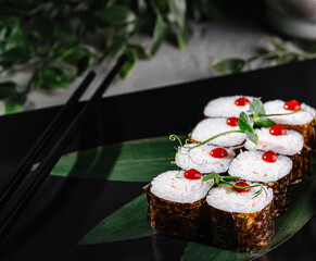 Sushi rolls set served on black plate close up