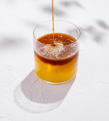 Bartender pouring espresso shot into glass of alcoholic cocktail