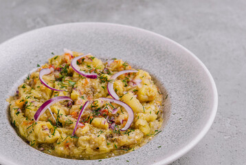 Baba ghanoush with red onions and herbs on a plate