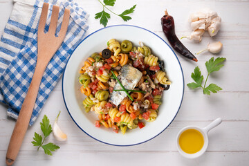 Italian pasta with sardines and black olives. Top view table with  decorations.