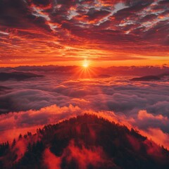 Highly dramatic sunrise scenery from above the fog. Panoramic aerial view of a beautiful landscape with magnificent red light illuminating dark clouds and the mist