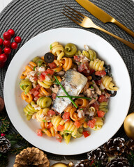 Italian pasta with sardines and black olives. Top view table with Christmas decorations.