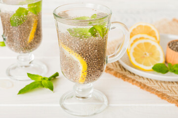 Healthy breakfast or morning with chia seeds lemon and mint on table background, vegetarian food, diet and health concept. Chia pudding with lemon and mint